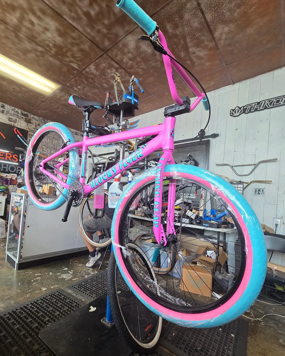 Hot pink SE Blocks Flyer custom build with teal and pink tires on the stand at 29ers Bike Shop