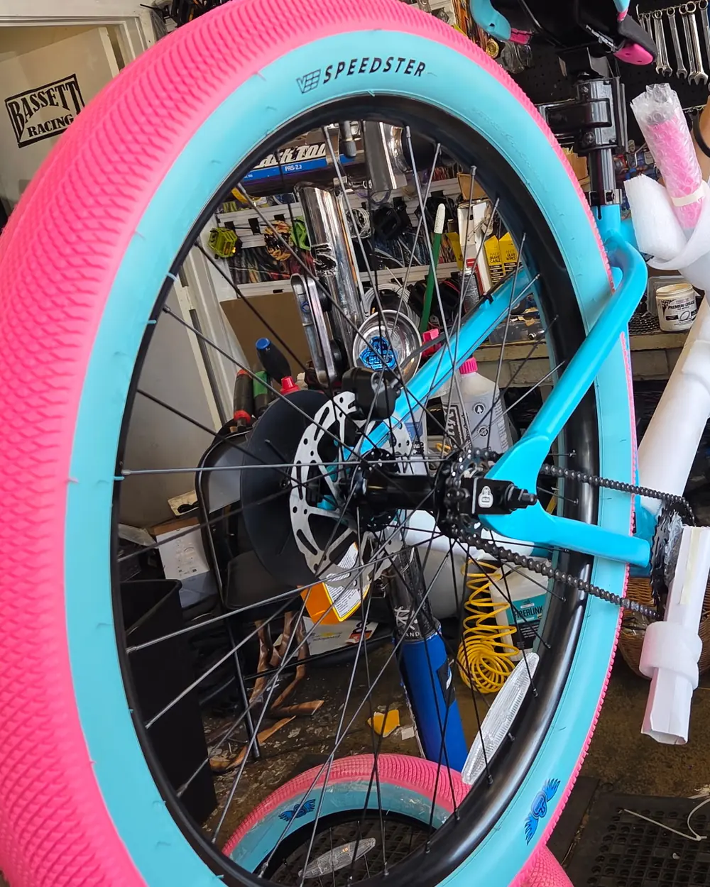 Sky-blue frame with hot pink Speedster tires being built on the repair stand