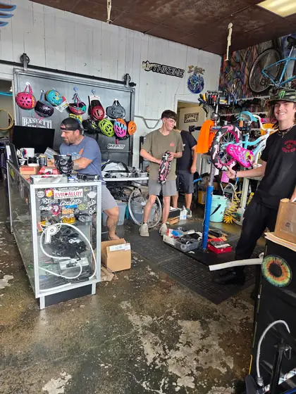 The 29ers crew at the counter and the repair stand working on a kids bike