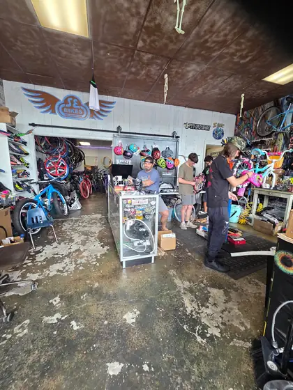 BMX bikes, wheels and parts lining the walls of 29ers Bike Shop with the service area in back