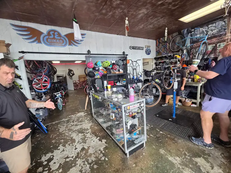 Inside 29ers Bike Shop in Kingwood, TX: the SE Bikes wall, helmet display and a bike up on the repair stand